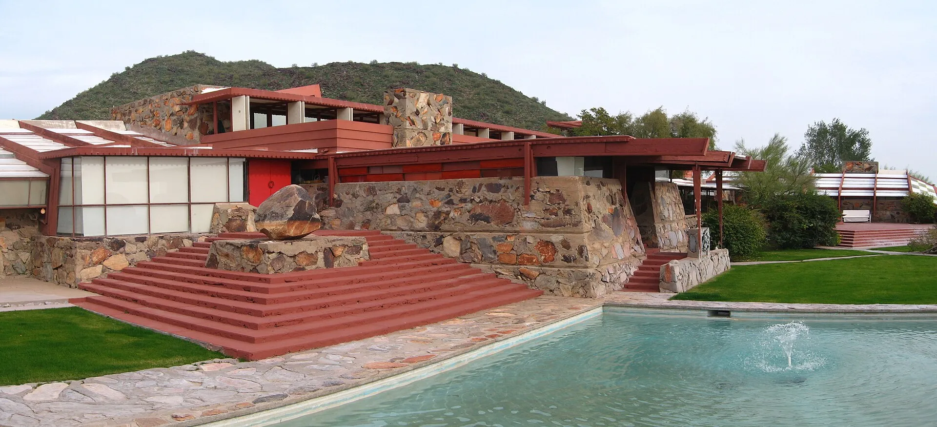 Taliesin West's low desert-masonry walls and red-beamed terrace above the triangular pool, Frank Lloyd Wright's winter home in Scottsdale